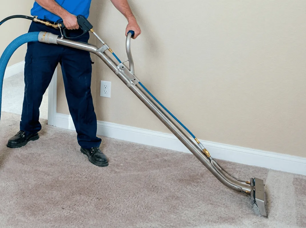 Professional operating a liquid removal machine on a carpeted floor in Madison, WI